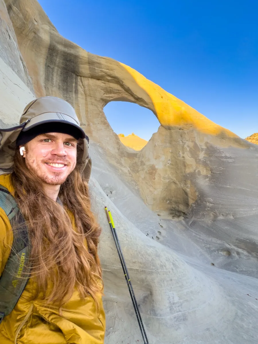 Chase smiling beside a sandstone arch in southern Utah.